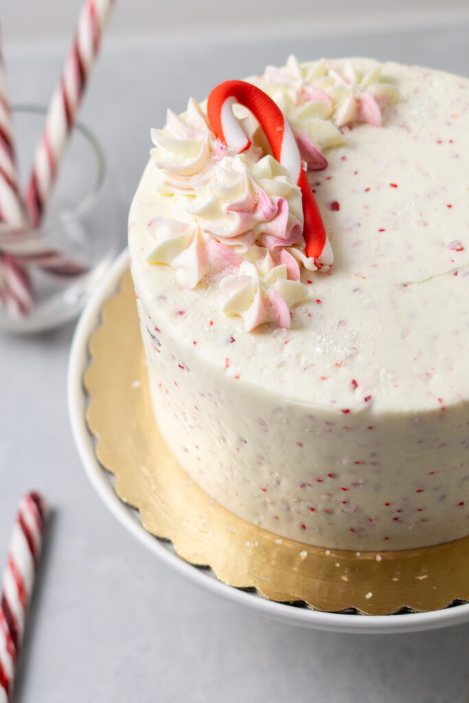 merry mint cake topped with pink and white buttercream decoration and a fondant candy cane